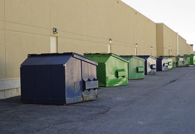 a series of colorful, utilitarian dumpsters deployed in a construction site in Coral Gables